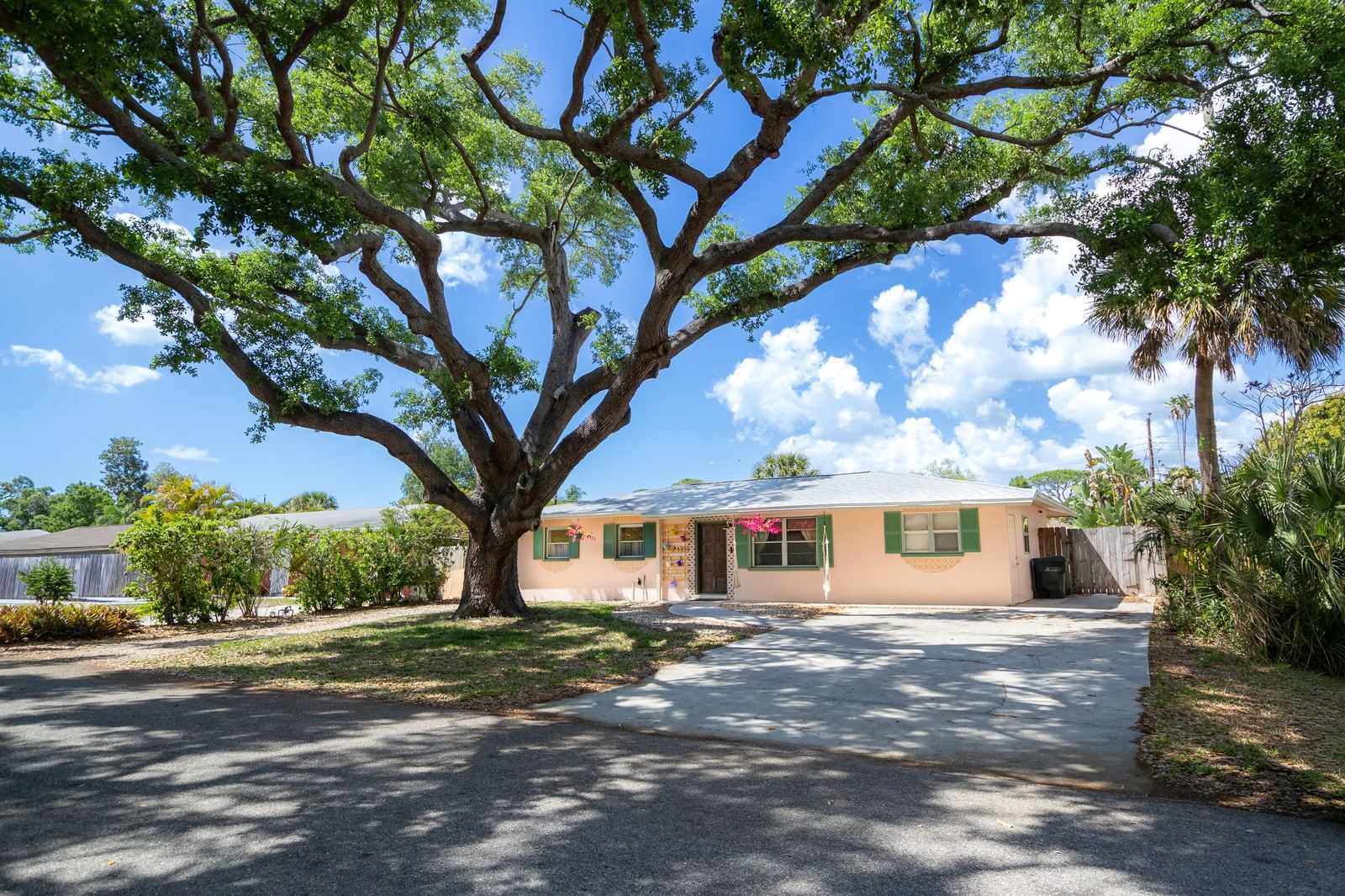 Front exterior of Siesta Tropical Escape under a grand oak tree in Sarasota